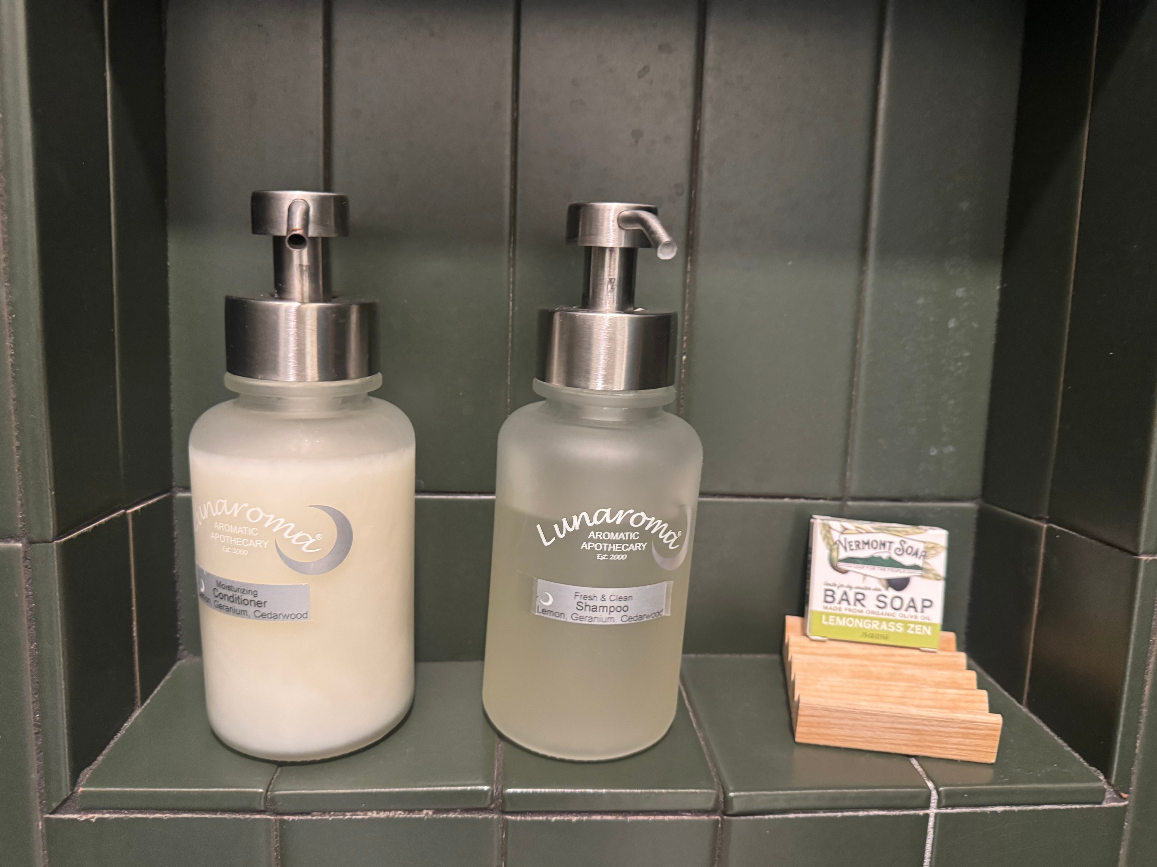 Hall bathroom shower niche with Lunaroma shampoo and conditioner dispensers and Vermont Soap bar on a cedar holder